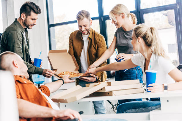istock successful happy entrepreneurs having pizza for lunch together while working on startup at office 1059568808