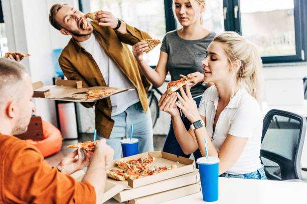 istock group of young entrepreneurs eating pizza for lunch together while working on startup at office 1059568872