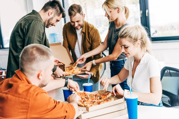 istock successful young entrepreneurs having pizza for lunch together while working on startup at office 1059568892