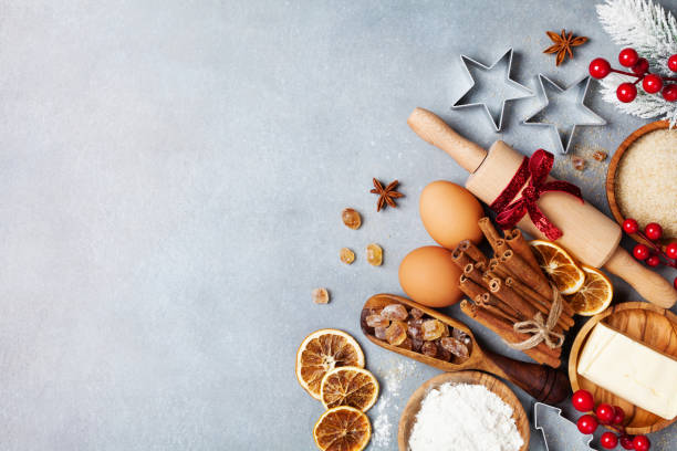 istock Bakery background with ingredients for cooking christmas baking decorated with fir tree. Flour, brown sugar, eggs and spices on kitchen table top view. 1059573210