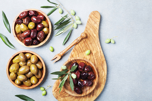 Natural greek olives in bowls with kitchen board from natural olive tree top view.