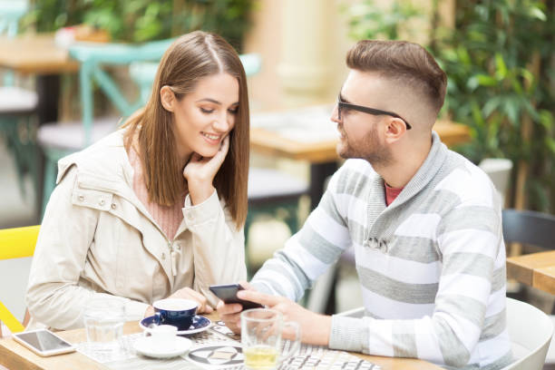 istock Young beautiful couple in cafe outdoors chatting 1059583894