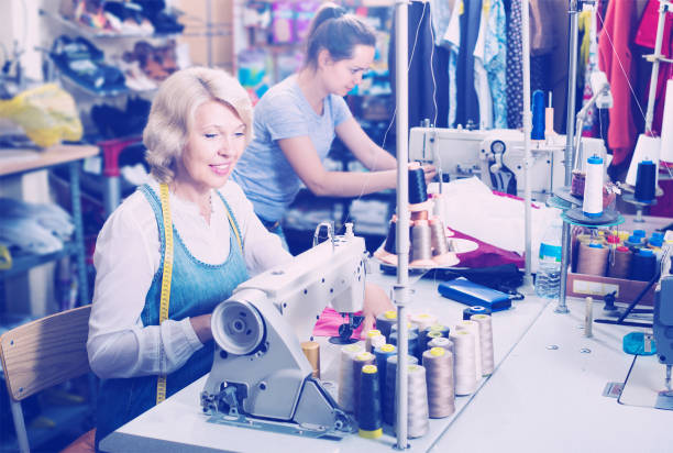 istock Two happy women tailors working with sewing machines 1059591484