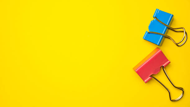 istock Red and blue paper binders on yellow background 1059593044