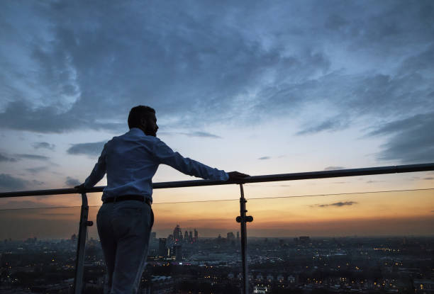 rückansicht des kaufmanns stehen gegen london ansicht panorama in der abenddämmerung. - roof men business city stock-fotos und bilder