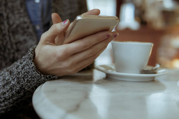 istock Woman using mobile phone in a cafe 1059597276