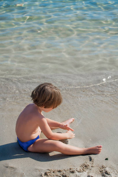 istock Cute little girl playing with sand on beach 1059602756