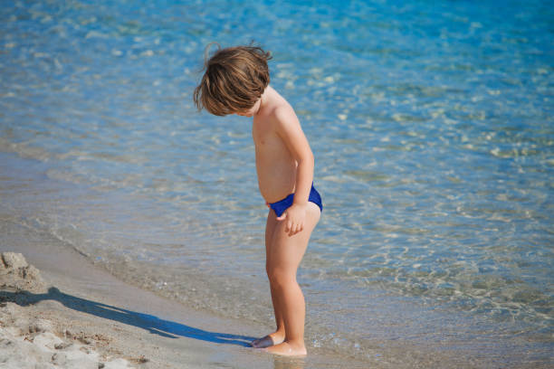 istock Cute little girl playing with sand on beach 1059602790
