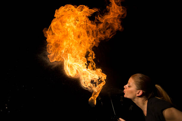 istock Fire breather blowing fire ball from her mouth 1059604100