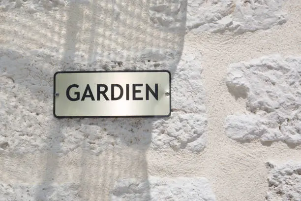 Photo of french sign on building outdoor gardien means guardian concierge service in french