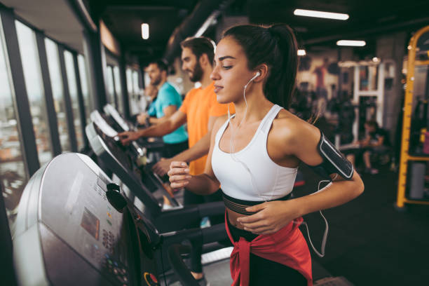 young woman exercising on treadmill - gym imagens e fotografias de stock