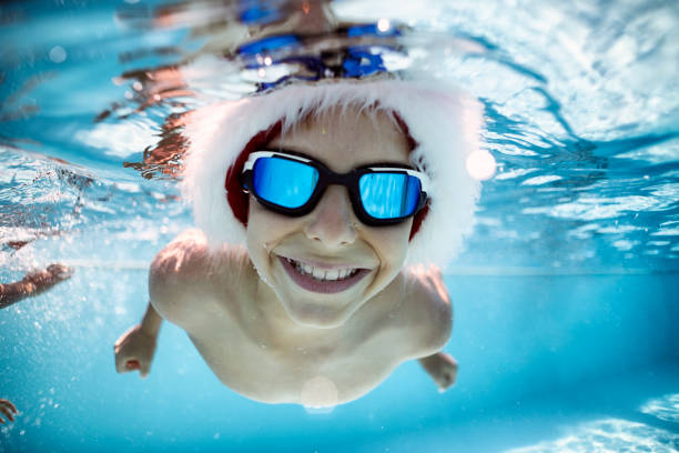 little boy playing in swimming pool during summer christmas - swimming child swimwear little boys imagens e fotografias de stock