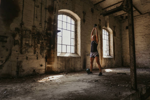 istock Athletic woman doing kettlebell swing in an old building 1059617556