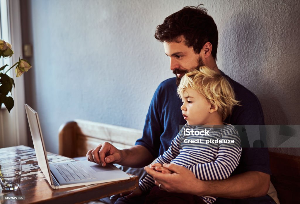 He wants to be just like his dad Cropped shot of a young man and his son using a laptop while sitting at the dining room table Family Stock Photo