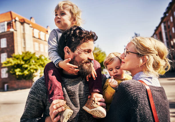 They're one happy family Cropped shot of an affectionate young couple taking a walk through the city lens flare offspring daughter human age stock pictures, royalty-free photos & images