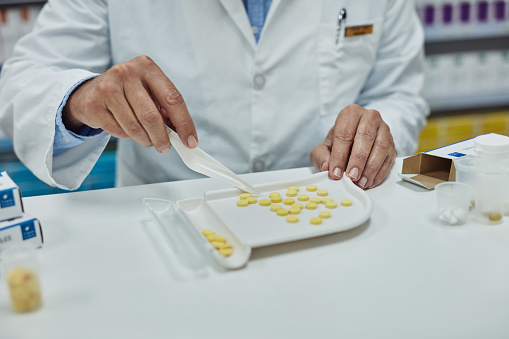 Cropped shot of a pharmacist counting medication in a chemist