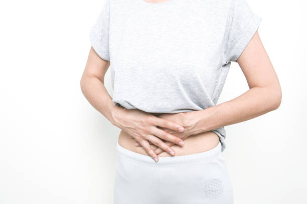 istock Stomach ache, women problems. Abdominal pain while sitting on bed at home. 1059626094