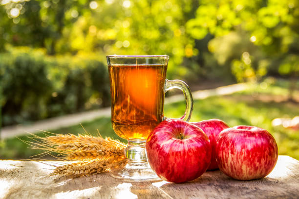 Cup of hot tea in the garden. Red apples and tea. Spiced Apple Tea. Autumn concept stock photo