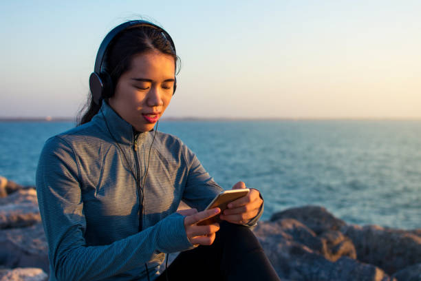 istock Woman enjoying music by the seaside 1059633012