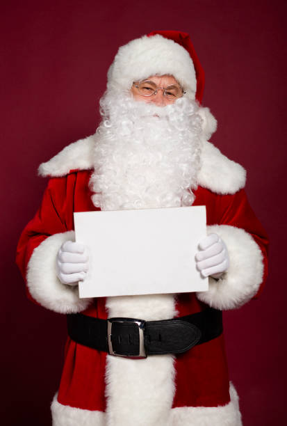 istock Happy grandfather Santa Clause showing white blank poster or board 1059636716