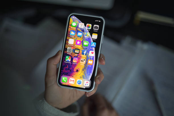 iPhone XS With Protective Case Celje, Slovenia - October 07, 2018: Woman holding new iPhone XS smartphone (with protective VRS design case, 5.8 inch Retina display, silver color version with 256 GB memory) in her hand over the note pad. apple computer stock pictures, royalty-free photos & images