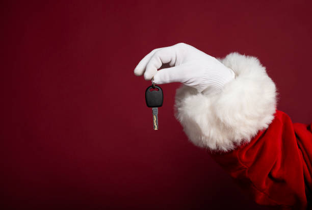 macho mano en guante blanco y santa claus traje celebración clave sobre fondo rojo, concepto de navidad y año nuevo - personal land vehicle fotos fotografías e imágenes de stock