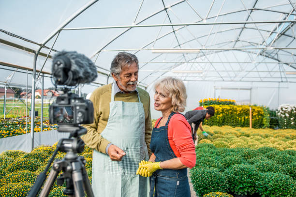 istock Two mature adults vlogging in a greenhouse 1059637074