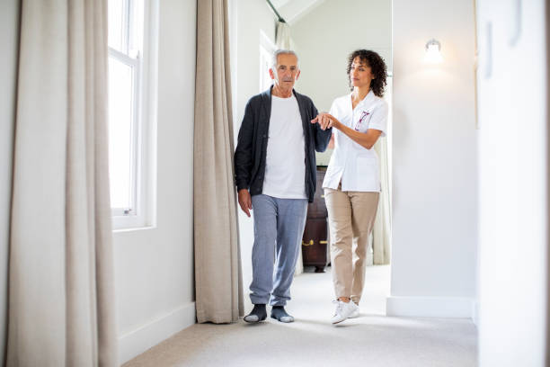 istock Nurse and patient walking in corridor at home 1059640302