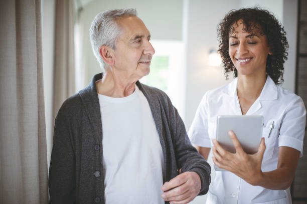 istock Smiling nurse holding digital tablet by patient 1059640704