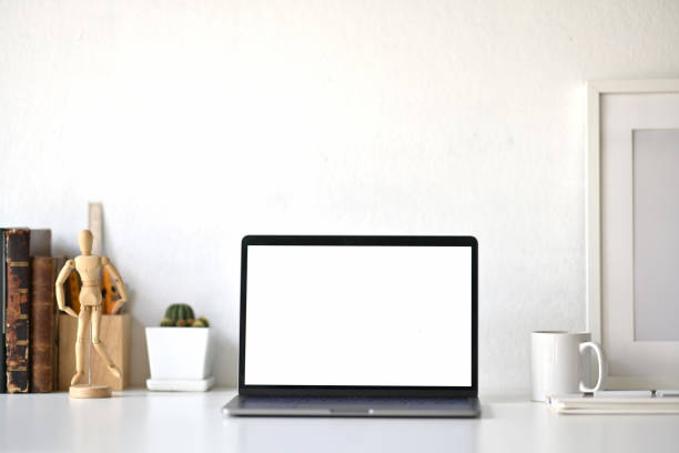 istock Workspace with blank white screen laptop on loft desk. 1059648444