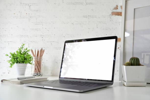 istock Workspace with blank white screen laptop on loft desk. 1059648448