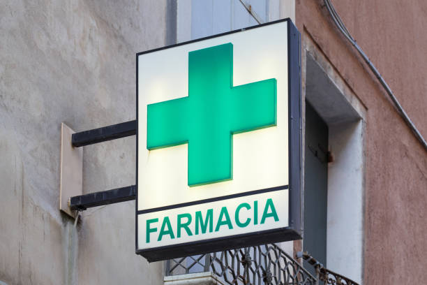 Pharmacy, farmacia sign with green illuminated cross in Italy Venice, Italy - August 13, 2017: Pharmacy, farmacia sign with green illuminated cross in Italy farmacia stock pictures, royalty-free photos & images