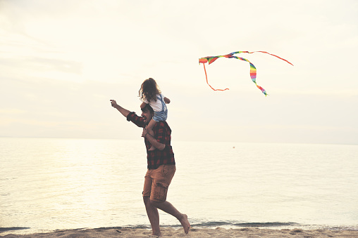 Father and daughter run across the beach and let the kite fly,The father and daughter spend time together, enjoy their free time