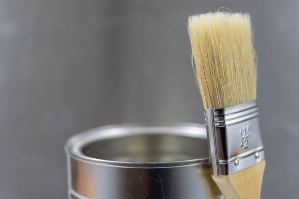 istock A paint brush and a can of paint on a workshop table. Painting accessories for construction workers. Light background. 1059652072