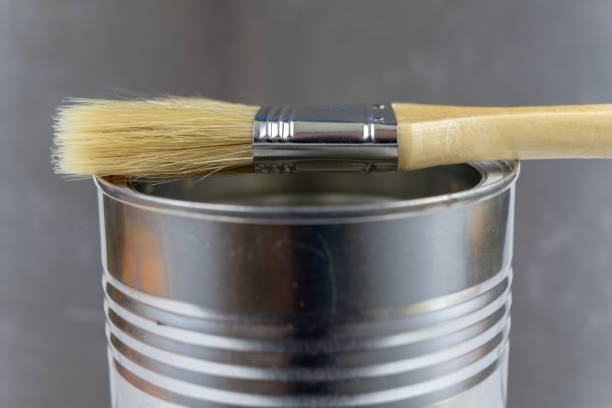 istock A paint brush and a can of paint on a workshop table. Painting accessories for construction workers. Light background. 1059652586