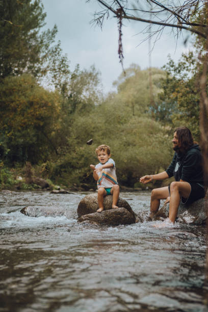 istock Boy playing in the river with his father 1059654946