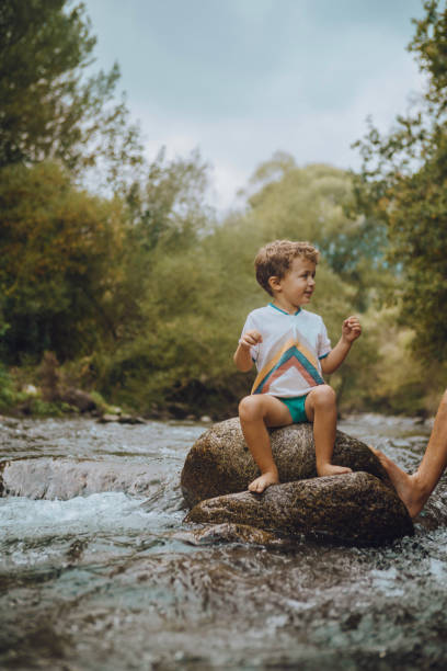 istock Boy playing in the river with his father 1059655180