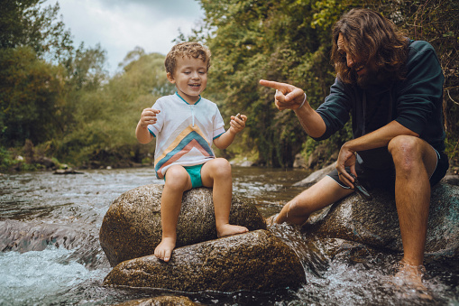 Boy playing in the river with his father