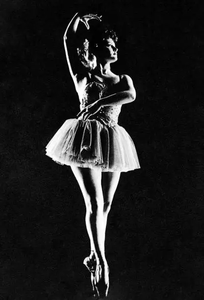 Vintage black and white contrasted image of a woman dancing ballet.