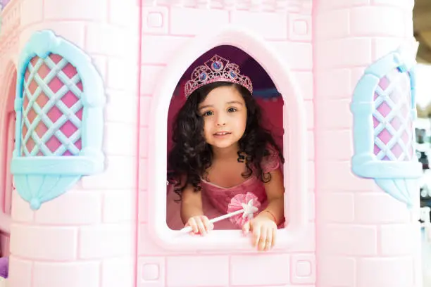Cute girl wearing princess attire in playhouse at home