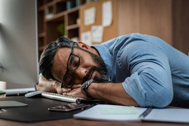 homme d’affaires fatigué dormant sur ordinateur de bureau - se courber en avant photos et images de collection