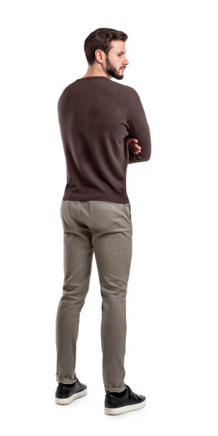 un hombre barbudo adulto suéter casual se encuentra en una vista posterior de que la mitad dio vuelta para mirar detrás de su hombro. - turn back fotografías e imágenes de stock