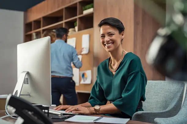 Photo of Young businesswoman smiling at office