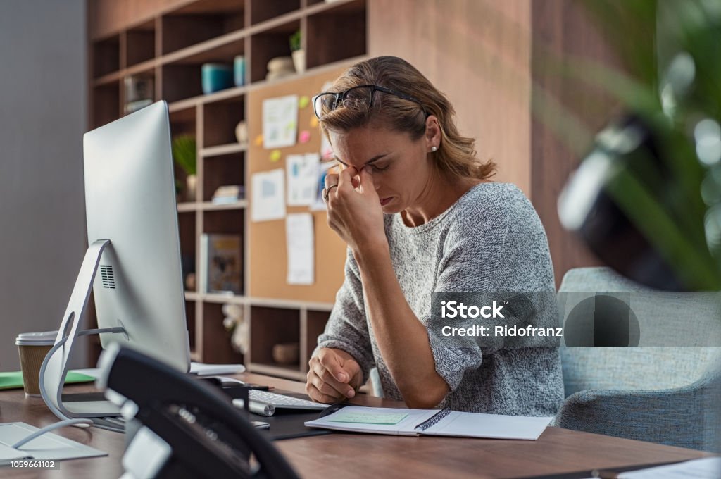 Деловая женщина с головной болью в офисе - Стоковые фото Эмоциональный стресс роялти-фри