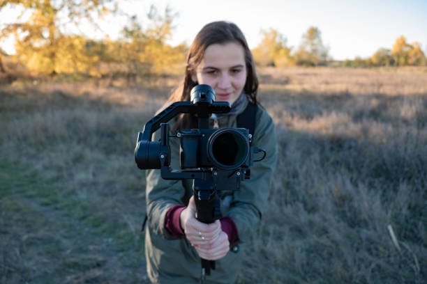 istock Female videographer holding a gimbal with mirrorless camera 1059661122