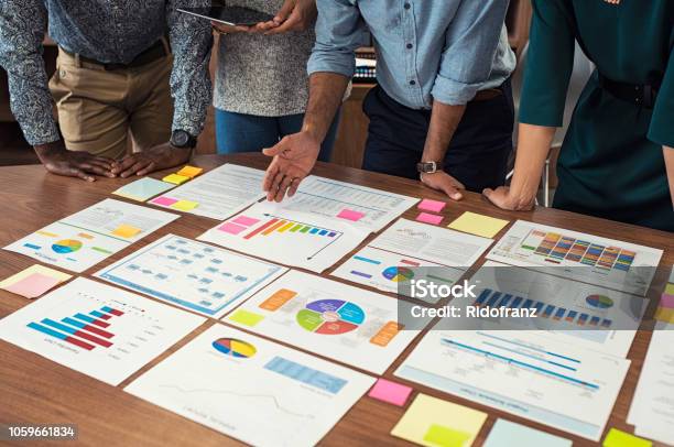 Business Casual Team Working On Graphs Stock Photo - Download Image Now - Data, Planning, Report - Document