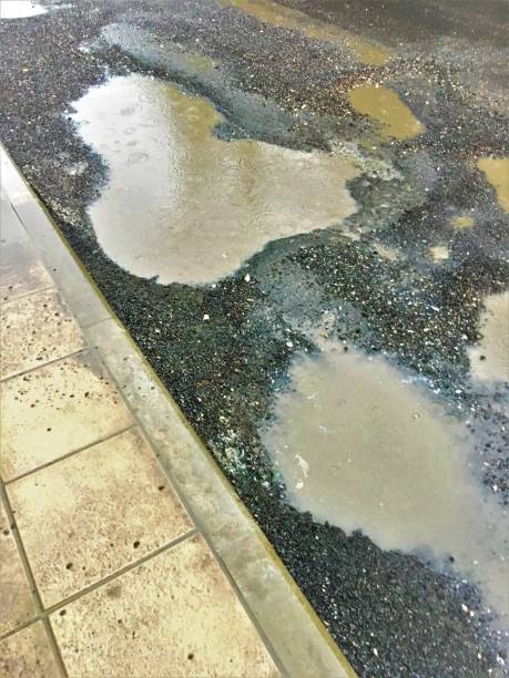 istock Bad  road  with potholes and puddles in huge pit 1059664090