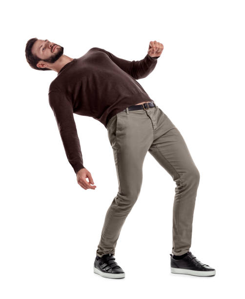 A bearded fit man in casual clothes stands with his back deeply bent backwards on a white background. A bearded fit man in casual clothes stands with his back deeply bent backwards on a white background. Loss of position. Falling man. Risky move. dipping stock pictures, royalty-free photos & images