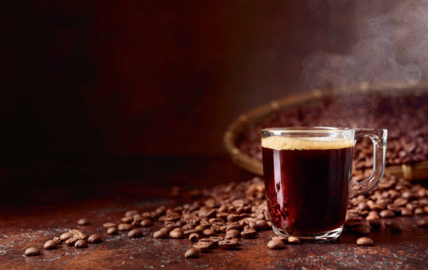 istock Black coffee in small glass cup on a table with coffee beans. 1059674834