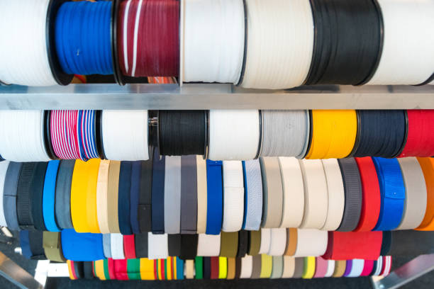 istock Colourful embroidery thread spool using in garment industry, row of multicoloured yarn rolls, sewing material selling in the market 1059678096